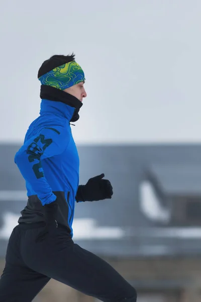 Jongeman atleet lopen in de winter buiten — Stockfoto