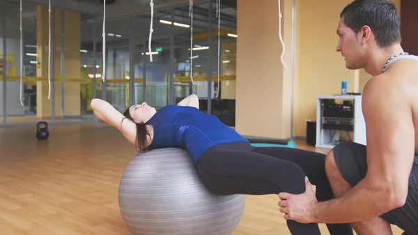 Mujer joven deportiva con instructor de fitness haciendo abdominales crujidos en fitballs — Foto de Stock