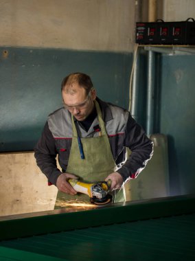 İşçilik - adam işçi bitki üzerinde çelik mekanizması taşlama