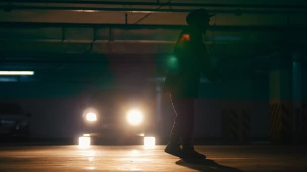 Молодий вільний чоловік робить акробатичні стрибки на підземному паркінгу — стокове відео
