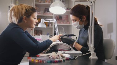 Küçük işletme - manikürcü - tırnak tıbbi maskesi profesyonel manikür yaparken ana