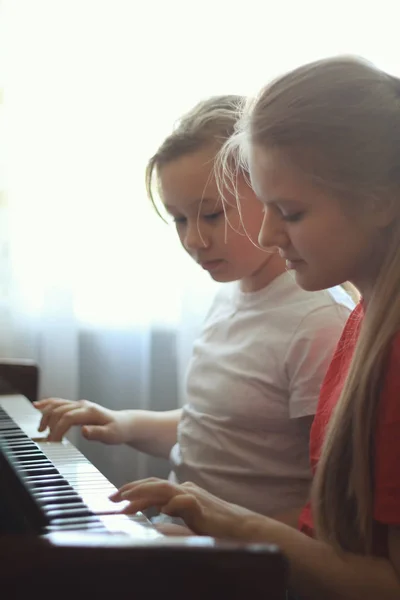 Due adolescenti sorelle ragazza 14 anni suona il pianoforte a casa, colpo verticale — Foto Stock