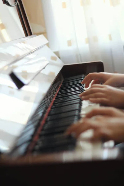 Due mani di adolescenti suonano su pianoforte - concetto musicale — Foto Stock