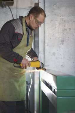 İşçilik - adam işçi bitki üzerinde çelik mekanizması taşlama