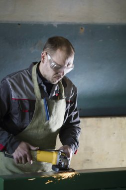 İşçilik - adam işçi bitki üzerinde çelik mekanizması taşlama