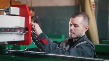Portre elektrikçi tulum üzerinde bitki enerji paneli ve makine ekipmanları ile çalışma