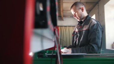 Elektrikçi tulum içinde bitki enerji paneli ve makine ekipmanları ile çalışma