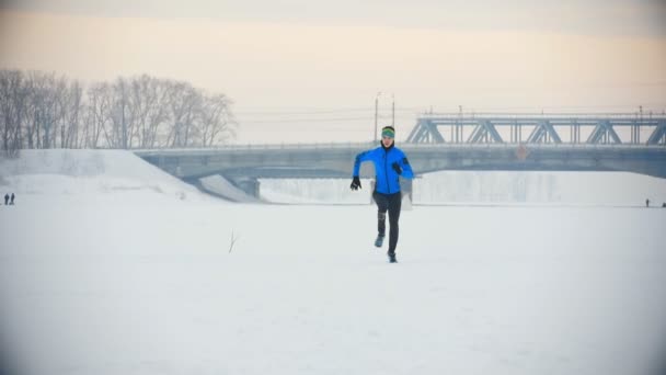 Junge männliche Athleten rennen im Winter schnell durch das verschneite Eisfeld — Stockvideo