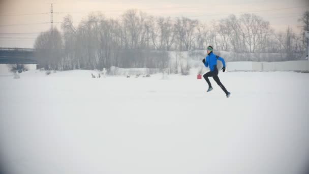 Hombre atleta corriendo en invierno al aire libre — Vídeos de Stock