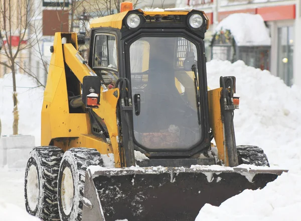 Limpiando nieve de la carretera con excavadora en la ciudad — Foto de Stock