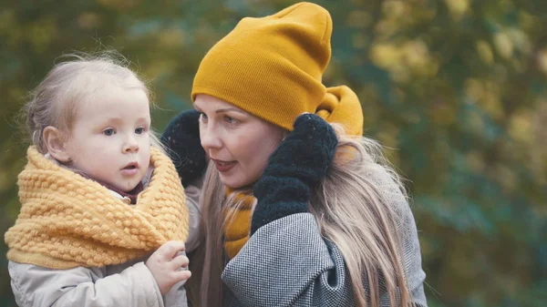 Linda hijita con su mami pasea en el parque de otoño — Foto de Stock