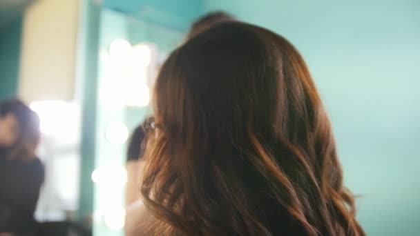 Maquillaje artista en salón de belleza hace visage para atractiva joven mujer, de cerca — Vídeos de Stock