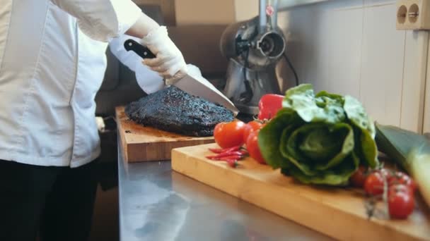 Резка большого куска копченого мяса на деревянной доске — стоковое видео