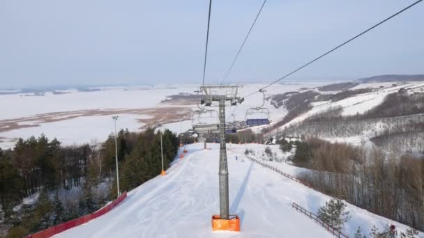 Вид из кабины канатной дороги на горнолыжный курорт в солнечный зимний день — стоковое видео
