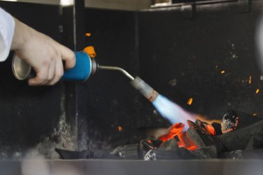 Şef ızgara et yemek pişirmek için kömür kıpırdanırken
