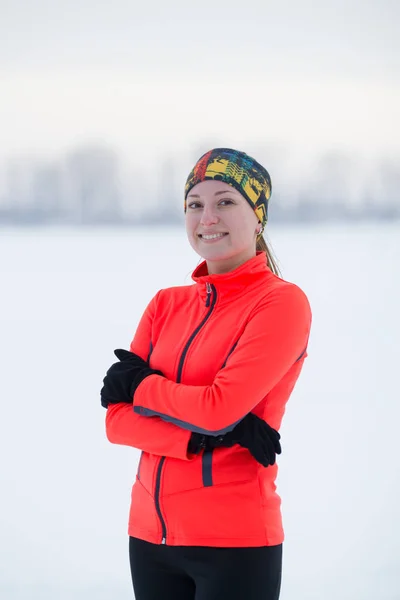 Portret van een blonde lachende jonge vrouwelijke Sportvrouw in winter ijs veld — Stockfoto