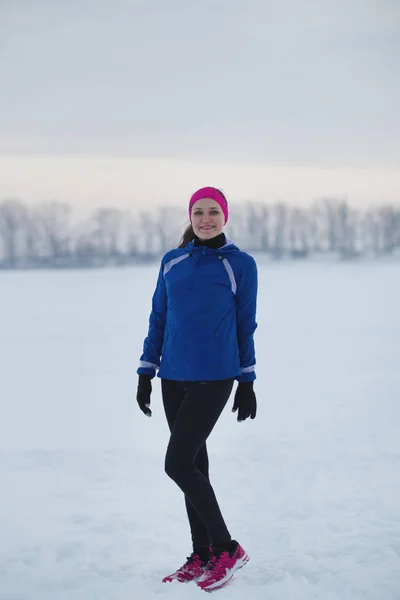 Portret van een lachende jonge vrouwelijke Sportvrouw in winter ijs veld — Stockfoto