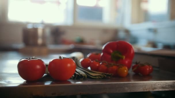Légumes, tomates, paprika, poireaux allongés sur la table dans la cuisine commerciale — Video