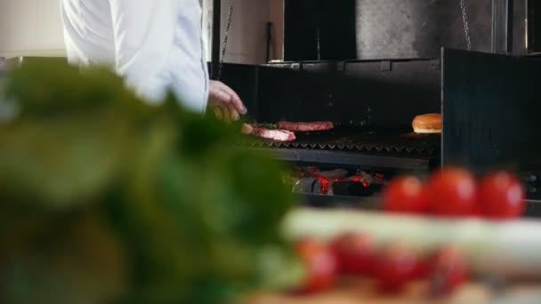 Chef prepara carne a la parrilla engrasándolo con aceite, verduras frescas en primer plano — Vídeos de Stock