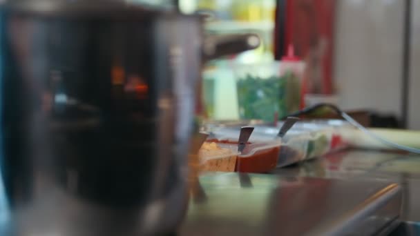 Cozinha comercial, carne e especiarias na mesa, panela no fogão — Vídeo de Stock