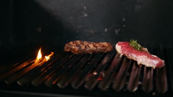 Duas fatias de carne de diferentes graus de prontidão estão na grelha. — Vídeo de Stock