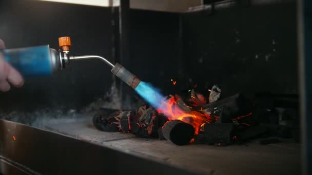 Aanmaakhout van houtskool in de oven van de barbecue met een gasbrander — Stockvideo