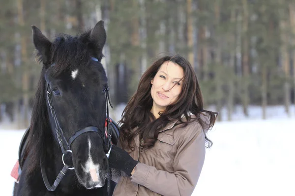 Jovem mulher de cabelo preto abraçando um cavalo - retrato — Fotografia de Stock