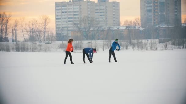 Grupa sportowców wykonuje ćwiczenia w zimie lodowisko — Wideo stockowe