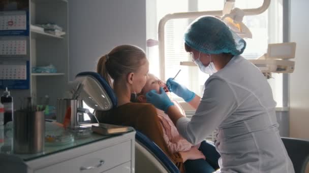 Menina com mamãe na sala de dentista — Vídeo de Stock