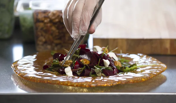 Шеф-повар готовит и подает салат на кухне ресторана — стоковое фото