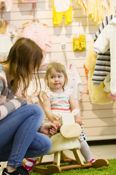 La niña con mamá en la tienda de ropa — Foto de Stock