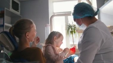 Kız, annesi ve diş hekimi diş office, incelenmesi ve danışmanlık stomatologist, kızı meraklı ve uysal