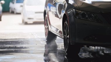 Sabun köpüğü bir arabaya su hortumlar tarafından yıkama, siluet