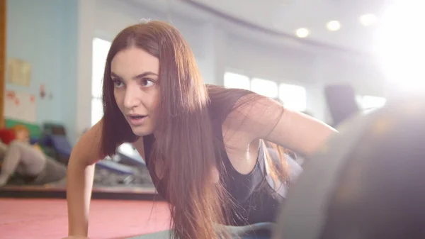 Deportiva atractiva mujer haciendo flexiones en el gimnasio —  Fotos de Stock