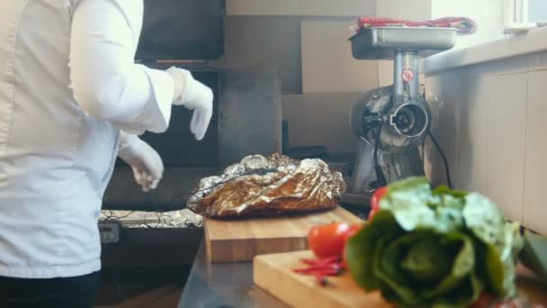 A konyhában az étterem vezetője készül egy nagy darab füstölt hús, egy fából készült hajón — Stock videók