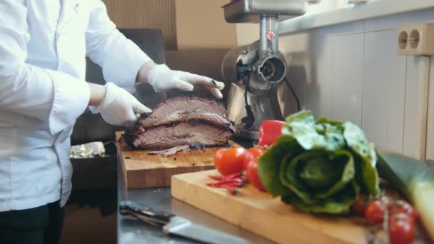 Découpe d'un gros morceau de viande fumée sur une planche de bois — Video