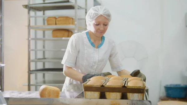 Женщина печет хлеб на коммерческой кухне — стоковое фото