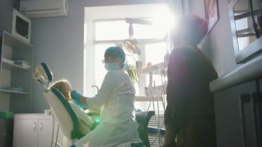 Diş hekimi resepsiyonda kız, stomatologist Childs'ın diş gülümseyen sevimli ve yaramaz kız inceliyor