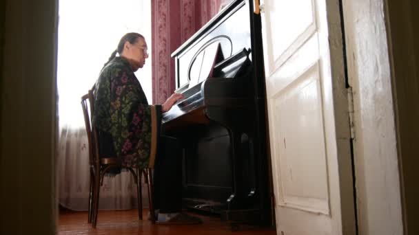 Senior mulher em casa está tocando piano — Vídeo de Stock