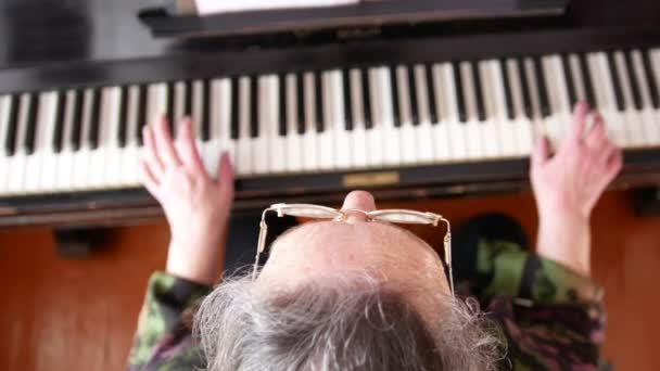 Старша жінка в окулярах грає на піаніно — стокове відео