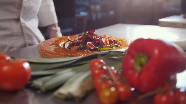 Szef kuchni serwuje sałatki, dodając sos, świeże warzywa na pierwszym planie — Wideo stockowe