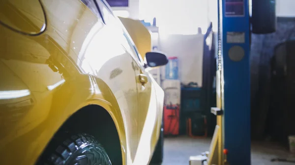 Yellow car in garage auto service - diagnostics and repairing