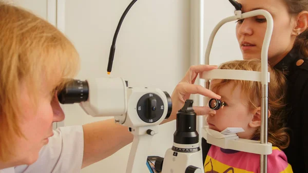 Kindergesundheit - kleines Mädchen mit Mama in Augenklinik überprüft Sehvermögen — Stockfoto