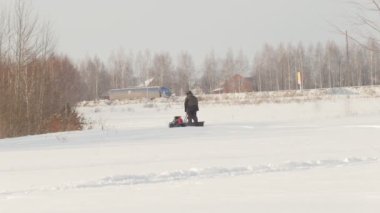 Adam mini Karmobil alanında derin snowdrifts üzerinde sürme, kar ile yürüyüş ve ellerini sallayarak kış giysileri