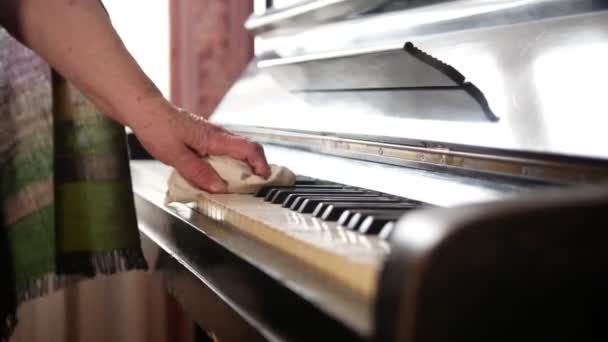 Ηλικιωμένη γυναίκα στο σπίτι σκόνη σκουπίζει στο πιάνο — Αρχείο Βίντεο