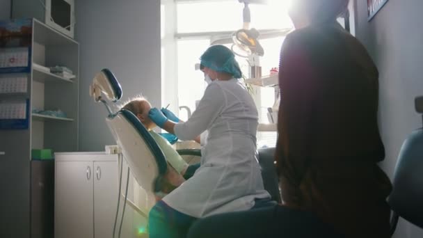 Маленька дівчинка з мамою в стоматологічній кімнаті — стокове відео