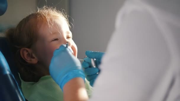 Chica en recepción en el dentista, el estomatólogo que lleva a cabo el procedimiento de limpieza — Vídeos de Stock