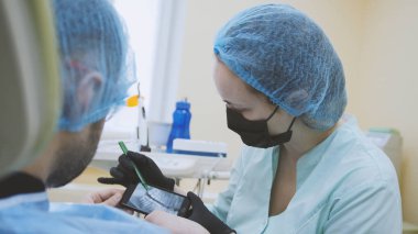 Genç kadın dişçide hasta ile ofiste iş