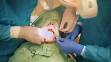 Çürüyen bir diş stomatology odasında kaldırmak için cerrahi pense kullanarak diş hekimi