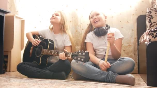 Zwei weibliche Teenager spielen zu Hause Musikinstrumente — Stockvideo